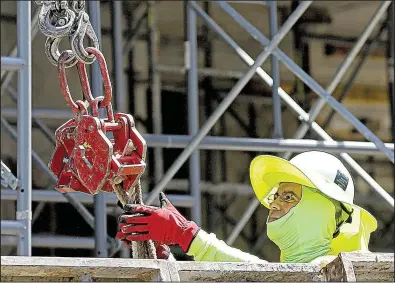  ?? AP/ALAN DIAZ ?? A constructi­on worker builds a condominiu­m complex in Coral Gables, Fla., earlier this week. The new Labor Department report said constructi­on companies added 16,000 jobs in June.