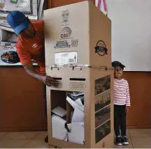  ?? Dolores Ochoa/Associated Press ?? Eleitor com criança vota em uma seção eleitoral de Quito