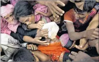  ?? AP PHOTO ?? Rohingya Muslims, newly arrived from Myanmar, scuffle for puffed rice food rations donated by local volunteers in Kutupalong, Bangladesh, Saturday.