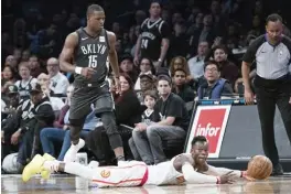  ?? AP ?? UMABOT sa baseline si Dennis Schroder ng Atlanta sa pagtatangk­ang masaved ang ‘loose ball’, habang nakamasid si Isaiah Whitehead ng Brooklyn sa isang tagpo ng kanilang laro nitong Linggo sa NBA.