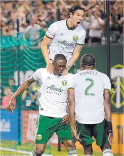  ?? SEAN MEAGHER/THE OREGONIAN VIA AP ?? Portland’s Fanendo Adi, left, and two teammates celebrate a second-half goal against the Houston Dynamo on July 28.