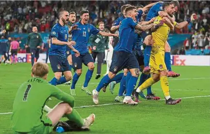  ?? AFP ?? Los jugadores de la selección italiana rodean a su arquero, Gianluigi Donnarumma, tras ser la gran figura de la final y de la Eurocopa.