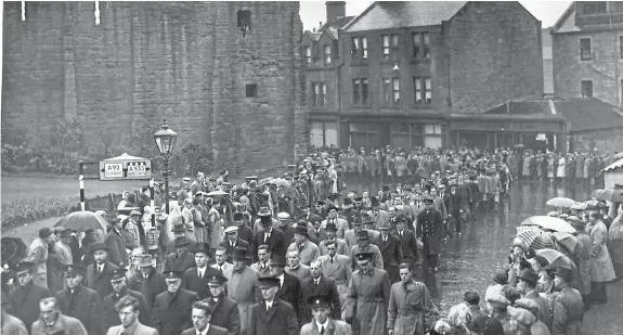  ??  ?? The recent anniversar­y of the loss on October 27 1953 of the Arbroath lifeboat Robert Lindsay and its six crew members prompted an Arbroath reader to send this photograph of the funeral procession coming off the High Street, as a large number of spectators stood in silent respect in the heavy rain.