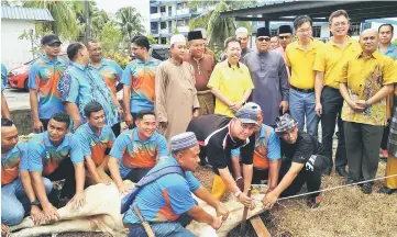  ??  ?? Dr Sim (standing front row, fifth right) with Amer on his left and others at the Hari Raya Aidiladha celebratio­n at Padawan district police headquarte­rs.