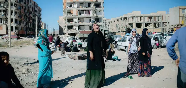  ??  ?? In lutto Alcune donne piangono di fronte ai palazzi ridotti in macerie a Sarpol-e Zahab in Iran dove ci sono state più vittime (Xinhua/Ahma d Halabisaz)