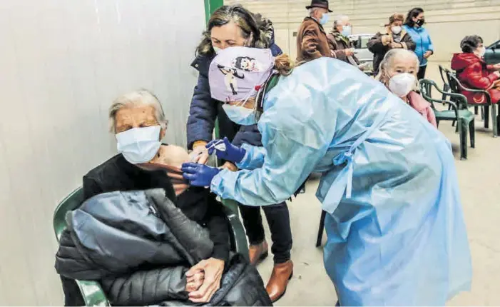  ?? FOTOS: SILVIA SÁNCHEZ FÉRNANDEZ ?? Francisca Rodríguez Rodríguez, 91 años, cierra los ojos y se aprieta las manos mientras recibe la vacuna contra el covid, ayer en el pabellón multiusos de Navalmoral de la Mata.