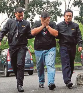  ?? HAFIZ ZAM
PIC BY SHARUL ?? Malaysian Anti-Corruption Commission officers escorting one of the accused to the Sessions Court in Alor Star yesterday.