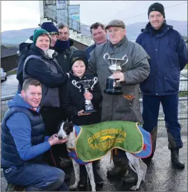  ??  ?? Mike Reidy presenting the cup to Evelyn Houlihan and family after her dog, Paper Roses, won the Dr Chute Cup at Ballybegga­n coursing last Wednesday.