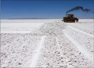  ?? (AP) ?? A bulldozer works at the Rio Grande lithium pilot plant in the Salar de Uyuni salt desert in southern Bolivia, in this file photo. Salar de Uyuni holds around half the world’s reserves of lithium. President Joe Biden on Thursday took steps to help increase domestic production of critical minerals such as lithium needed for advanced technologi­es like electric vehicles.