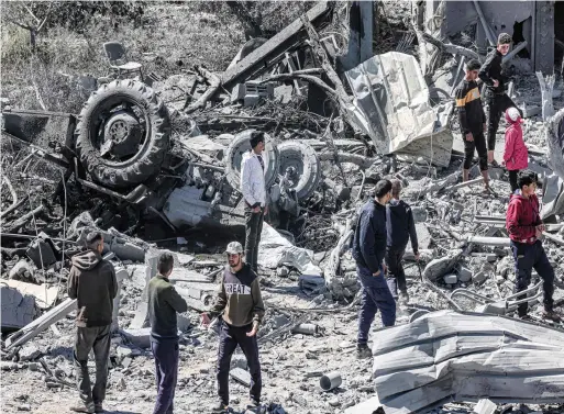  ?? — AFP ?? People inspect the rubble and debris of a building that collapsed following an Israeli air strike in the Rafah refugee camp in the southern Gaza Strip on Wednesday.