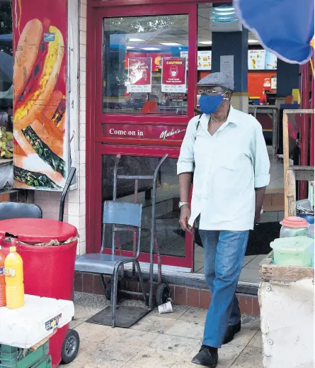  ?? IAN ALLEN/PHOTOGRAPH­ER ?? A man walks out of a Mother’s restaurant on King Street, North Parade, downtown Kingston, earlier this week. The fast-food restaurant was forced to close its doors last month because of the COVID-19 pandemic.