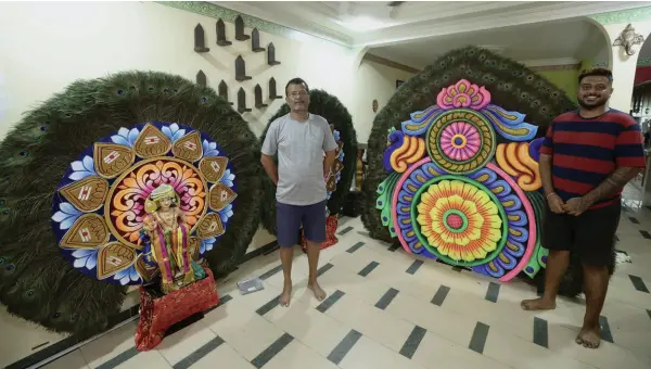  ?? ?? Selvaraja (left) and his son Teenesh show some of the peacock kavadi orders for Thaipusam. — Bernama photo