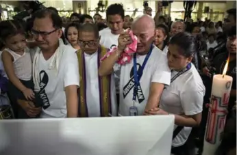  ?? NOEL CELIS/AFP/GETTY IMAGES ?? Parents and relatives of the slain 17-year-old weep over his coffin during a mass before the burial on Saturday.