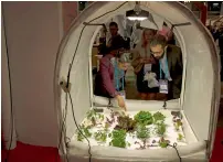  ?? — AP ?? Visitors look at vegetables growing inside Living Box, a mobile farming system, at the Mobile World Congress in Barcelona.