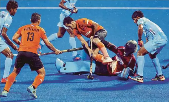 ?? PIC BY MUHAIZAN YAHYA ?? Malaysia’s Tengku Ahmad Tajuddin Abdul Jalil (centre) tussles for the ball with India goalkeeper Suraj Karkera (second from right) in an Azlan Shah Cup match in Ipoh yesterday.