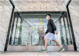  ?? AFP ?? A man walks past a luxury store in a shopping district in Hong Kong in October of last year.