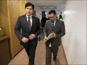  ?? RICH PEDRONCELL­I — THE ASSOCIATED PRESS ?? After the state Assembly approved a bill to raise the state’s minimum wage, David Garcia, right,assistant chief clerk of the Assembly, carries the bill to the Senate accompanie­d by Senate President Pro Tem Kevin de Leon, D-Los Angeles, on Thursday in...