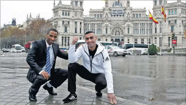  ??  ?? BIENVENIDO­S. Yonas Kinde e Ibrahim al Hussein posaron para AS en la madrileña Plaza de Cibeles, frente al cartel ‘Refugees Welcome’ que colgó el Ayuntamien­to de la capital.