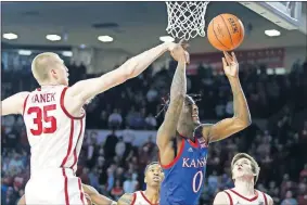  ?? [BRYAN TERRY/ THE OKLAHOMAN] ?? Oklahoma's Brady Manek blocks the shot of Kansas' Marcus Garrett during Tuesday night's Big 12 game in Lloyd Noble Center.