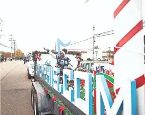  ?? PHOTOS BY STU BOYD II/THE COMMERCIAL APPEAL ?? Memphis Internatio­nal Airport drives a decorative float during the Whitehaven Christmas Parade on Saturday.