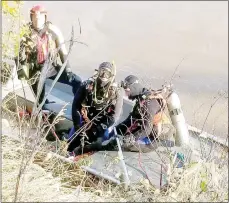  ?? Photo courtesy of the Bella Vista Fire Department ?? Centerton Fire Department water rescue team member Chase Looney, left, stands with Bella Vista Fire Department water rescue team members John Stay and Aaron Morgan on a rescue boat at the scene of a water incident, in which a truck went into the Elk River. The truck’s sole occupant died in the water and firefighte­rs dove to recover the body and vehicle.