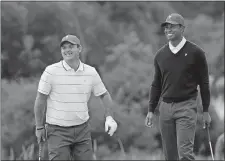  ?? ANDY BROWNBILL/AP PHOTO ?? Patrick Reed, left, and captain Tiger Woods smile during a practice session on Tuesday ahead of the President’s Cup at Melbourne.