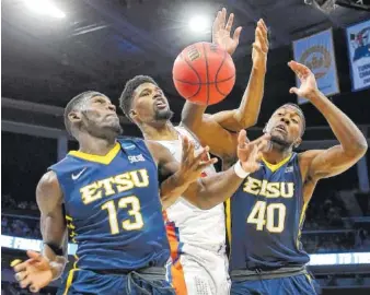  ?? THE ASSOCIATED PRESS ?? East Tennessee State guard A.J. Merriweath­er (13) and forward Tevin Glass (40) scramble for a loose ball against Florida forward Kevarrius Hayes during the first half of their game Thursday in Orlando, Fla.