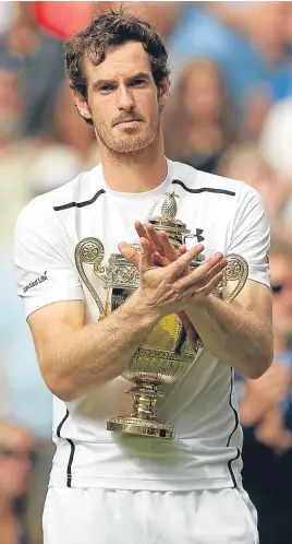  ??  ?? Andy Murray keeps a tight grip on the Wimbledon trophy.