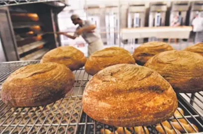  ?? Helen H. Richardson, The Denver Post ?? Baker John Groundwate­r takes fresh loaves out of the oven at the Grateful Bread Company in Golden.