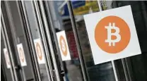  ?? Mark Lennihan / Associated Press ?? Bitcoin logos are displayed at a trade show in New York. Bitcoin slumped 9.5 percent to $14,042 Friday.