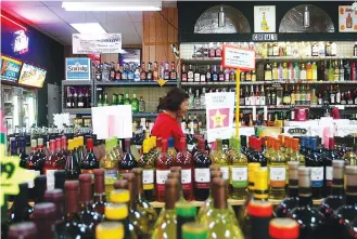  ?? STAFF FILE PHOTO ?? Eduarda Jimenz walks toward Cox’s Spirits’ check out counter after selecting her purchase in Dalton, Ga. This week Georgia Gov. Brian Kemp signed legislatio­n allowing delivery of alcohol to residents’ homes.