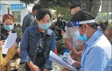  ?? PROVIDED TO CHINA DAILY ?? A volunteer translator (right) helps a person from Myanmar fill in personal informatio­n at a vaccinatio­n center on Saturday in Ruili, Yunnan province, near the Myanmar border.