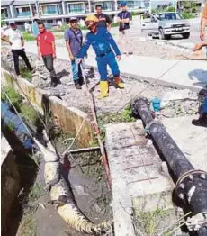  ?? [ FOTO IHSAN APM ] ?? Anggota APM menangkap buaya di tapak binaan di Kuching, semalam.