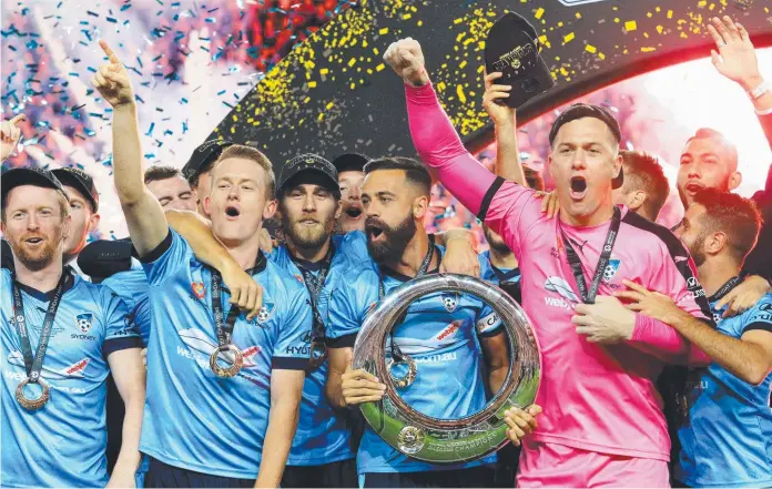  ?? CHAMPIONS: Delighted Sydney FC players raise the A- League Trophy after winning the grand final on penalties against Melbourne Victory in Sydney. Picture: MARK EVANS ??