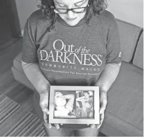  ??  ?? Kerry Mitchell holds a picture of her son, James, at her home. James died by suicide on April 23, 2007. After her son’s death, Kerry became an advocate for suicide awareness and prevention. BRAD VEST/THE COMMERCIAL APPEAL