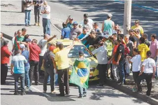  ??  ?? Taxistas cercam motorista que tentava passar pela Presidente Vargas no protesto em frente à prefeitura