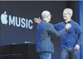  ?? Jeff Chiu
Associated Press ?? APPLE CEO Tim Cook, right, hugs Apple Music point man Jimmy Iovine at a conference Monday.