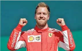  ?? THE ASSOCIATED PRESS ?? Formula One driver Sebastian Vettel celebrates after winning the British Grand Prix on Sunday in Silverston­e, England. Vettel extended his advantage in the season standings as well.