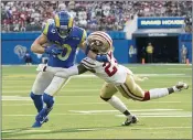  ?? ?? San Francisco 49ers defensive back Dontae Johnson (27) tackles Los Angeles Rams wide receiver Cooper Kupp (10) during the first half Sunday in Inglewood.