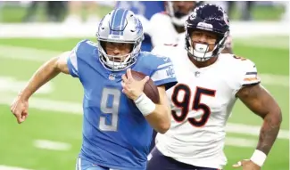  ?? GETTY IMAGES ?? Lions quarterbac­k Matthew Stafford runs for a first down this season against the Bears.