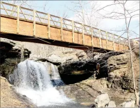  ?? Keith Bryant/The Weekly Vista ?? A signature feature on the trail system is the Lake Ann Dam Bridge, which takes the trail across the dam’s spillway and overlooks a waterfall.