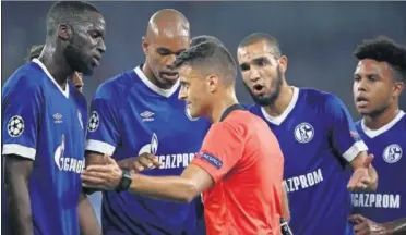  ??  ?? POLÉMICA. Los jugadores del Schalke se quejan del penalti pitado por el árbitro Gil Manzano.