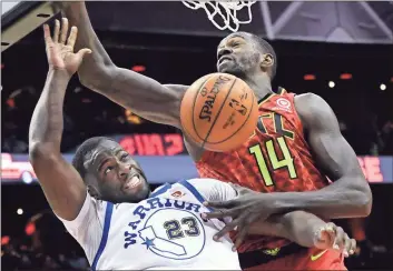 ?? John Amis / AP ?? Golden State’s Draymond Green (left) comes down after a dunk past Atlanta’s Dewayne Dedmon during the second half of Friday’s game in Atlanta. The Warriors were able to get by the Hawks for a 114-109 win.