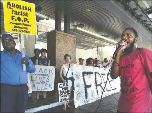  ?? (The Baltimore Sun/Amy Davis) ?? Activists Ralikh Hayes (right), coordinato­r for Baltimore Bloc, and the Rev. C.D. Witherspoo­n (left) of Peoples Power Assembly lead protesters in chants against the Fraternal Order of Police, outside the entrance to the Hyatt Regency at the Inner Harbor, where the Maryland Fraternal Order of Police opened their four-day convention in 2016 in Baltimore.