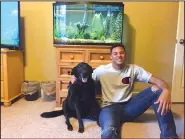  ?? Special to the Arkansas Democrat-Gazette ?? Zach Williams of Joe T. Robinson has loved animals for most of his life. Williams, a defensive end for the Senators, has a 50-gallon tank filled with a variety of fish in his bedroom. Sitting next to him is his dog Cairo, a member of Williams’ family...