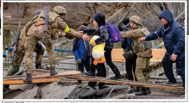  ?? ?? A WAY OUT: Ukrainian soldiers help a child across the planks that have replaced the destroyed bridge