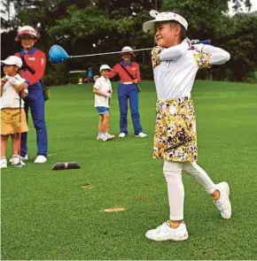  ?? AFP PIC ?? Lai Runci tees off during a children’s tournament on Sept 23 at the Dragon Lake Golf Club in Guangzhou.