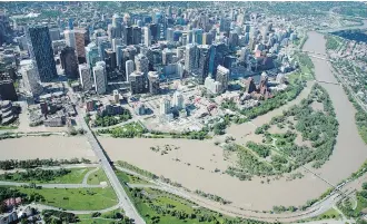  ?? JONATHAN HAYWARD/THE CANADIAN PRESS/FILES ?? More than 100,000 southern Albertans were displaced by 2013 flooding, which spilled into downtown Calgary streets and caused more than $6 billion in property damage.