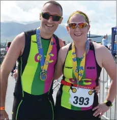  ?? Photo by Fergus Dennehy. ?? Tommy Commane and Michelle McGrath were all smiles as they posed with their medals after completing the Tri Kingdom Come in Fenit.