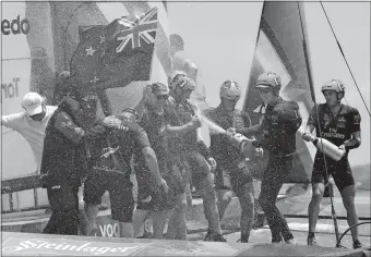  ?? GREGORY BULL/AP PHOTO ?? The crew of Emirates Team New Zealand spray champagne as they celebrate after defeating Oracle Team USA to win the America’s Cup sailing competitio­n on Monday in Hamilton, Bermuda.